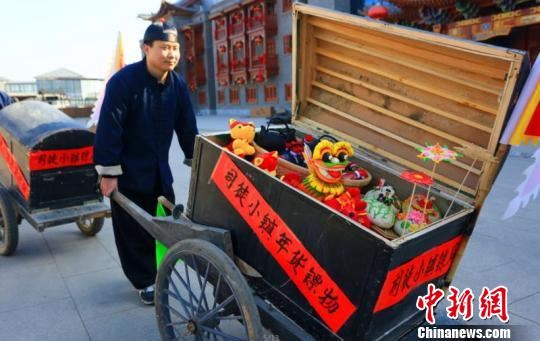 司徒小镇景区挑选了花馍、面塑、山西老陈醋等山西特色年货,由5名镖师押送货物在景区内展演。 李庭耀 摄 司徒小镇景区挑选了花馍、面塑、山西老陈醋等山西特色年货,由5名镖师押送货物在景区内展演。 李庭耀 摄