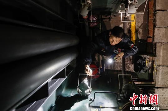 检修完车厢,他还需要对车厢与车厢之间的链接线路进行巡检。 张亨伟 摄 检修完车厢,他还需要对车厢与车厢之间的链接线路进行巡检。 张亨伟 摄