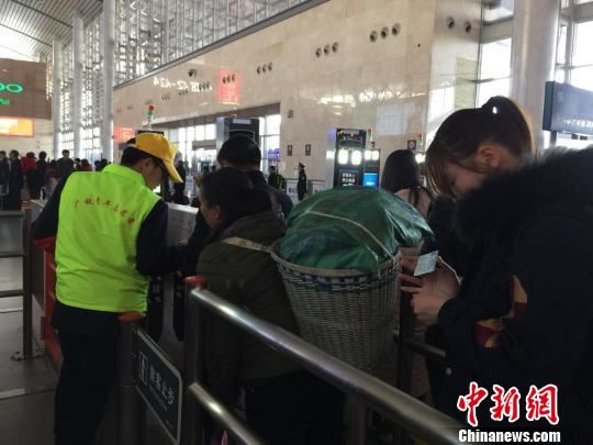 2月26日，长沙南站青年志愿者指导旅客“刷脸”通过自助验票通道。　鲁毅 摄