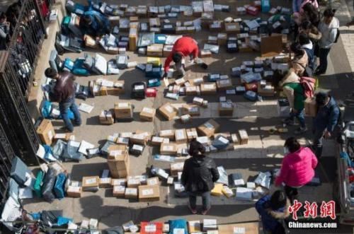 资料图:快递工作人员忙着分拣满地的快递。武俊杰 摄 点击进入下一页