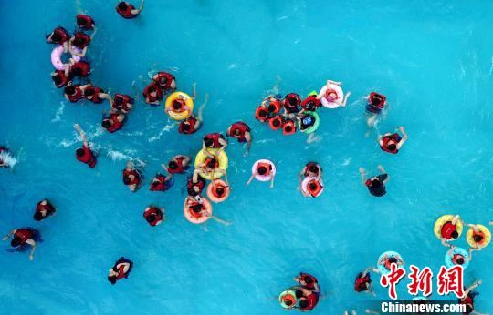 市民们纷纷换上泳装，水中觅清凉。　王剑　摄