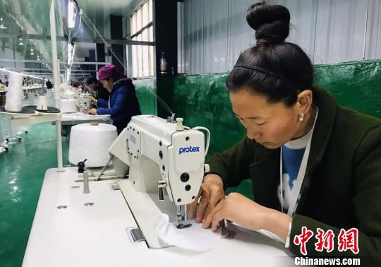 紧挨着坪垭藏族乡腰道村易地搬迁点的扶贫车间内,村民们在缝制宾馆用品。 艾庆龙 摄 紧挨着坪垭藏族乡腰道村易地搬迁点的扶贫车间内,村民们在缝制宾馆用品。 艾庆龙 摄